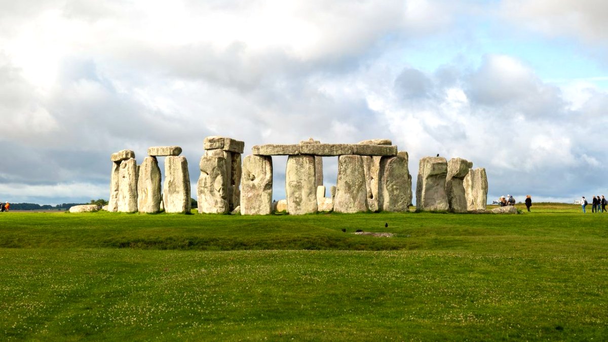 Il cerchio di pietre di Stonehenge su un prato verde sotto un cielo nuvoloso, una delle escursioni da Londra più popolari