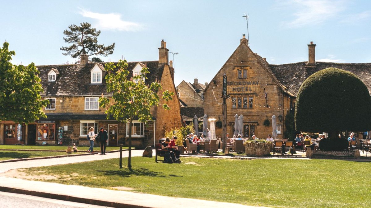 Il prato centrale di Broadway, nelle Cotswolds, con le case in pietra color miele e i tavolini all'aperto, una delle escursioni da Londra più amate